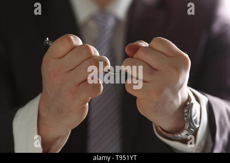 L'homme en costume et cravate plier l'ongle avec bras libre Banque D'Images