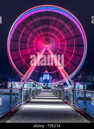 Rose et Turquoise filature grande roue à la nuit sur une froide nuit d'hiver à la fin d'une allée. Tourné dans le Vieux-Port de Montréal, Québec, Canada Banque D'Images
