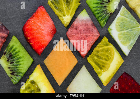 Composition abstraite de la forme en diamant divers puzzle de fruits noirs sur fond de pierre Banque D'Images