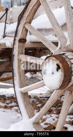 La verticale de près de l'rusty roues d'un wagon en bois patiné vue en hiver Banque D'Images