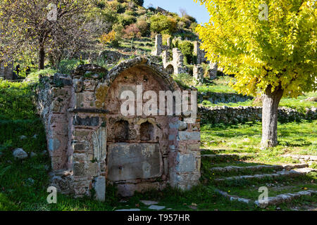 Partie de la site archéologique de Mystras byzantine dans le Péloponnèse, Grèce. Avis d'une vieille fontaine en pierre et le reste des bâtiments de la ville basse Banque D'Images