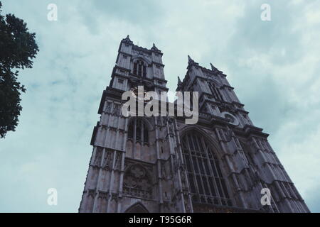 La célèbre Abbaye de Westminster, London, UK tourné en un faible angle de vue sur une journée nuageuse. Sur la gauche un arbre entre dans le cadre. Banque D'Images