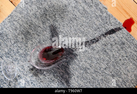 Osterode am Harz, Allemagne. 16 mai, 2019. ILLUSTRATION - un verre avec un peu de vin rouge se trouve sur un tapis à côté des taches sur les planches en bois. Frank May/alliance photo Credit : Frank May/photo de l'alliance/dpa/Alamy Live News Banque D'Images