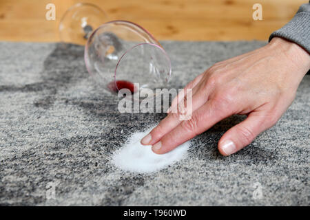 Osterode am Harz, Allemagne. 16 mai, 2019. ILLUSTRATION - un verre avec un peu de vin rouge se trouve sur un tapis à côté des tâches sur lesquelles le sel est frottée. Frank May/alliance photo Credit : Frank May/photo de l'alliance/dpa/Alamy Live News Banque D'Images