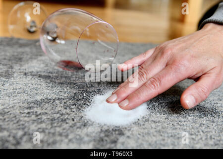 Osterode am Harz, Allemagne. 16 mai, 2019. ILLUSTRATION - un verre avec un peu de vin rouge se trouve sur un tapis à côté des tâches sur lesquelles le sel est frottée. Frank May/alliance photo Credit : Frank May/photo de l'alliance/dpa/Alamy Live News Banque D'Images