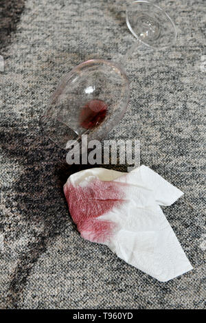 Osterode am Harz, Allemagne. 16 mai, 2019. ILLUSTRATION - un verre avec un peu de vin rouge se trouve sur un tapis à côté de taches fraîches et d'une serviette en papier. Frank May/alliance photo Credit : Frank May/photo de l'alliance/dpa/Alamy Live News Banque D'Images