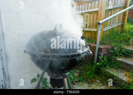 Un barbecue avec un couvercle sur la génération de beaucoup de fumée, Banque D'Images