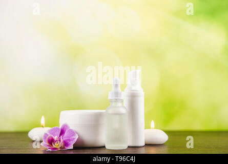 Divers contenants des produits de beauté table en bois brun foncé avec l'arrière-plan flou Flou vert, copiez l'espace. Banque D'Images