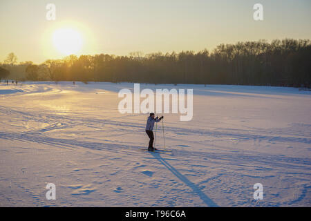 Jeune homme actif le ski de fond sur l'immense lac gelé pendant l'hiver magnifique coucher de soleil, Moscou, Russie, 30.12.2019 Banque D'Images