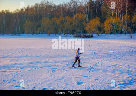 Jeune homme actif le ski de fond sur l'immense lac gelé pendant l'hiver magnifique coucher de soleil, Moscou, Russie, 30.12.2019 Banque D'Images