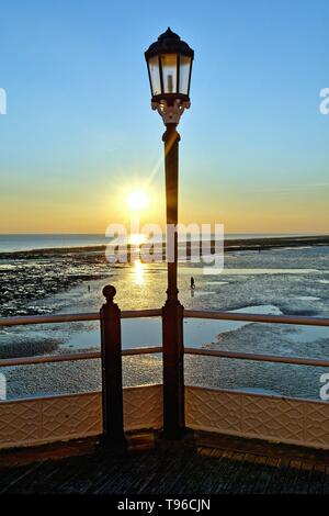 Lampadaire décoratif jetée de Worthing avec un hiver spectaculaire coucher de soleil sur la mer West Sussex England UK Banque D'Images