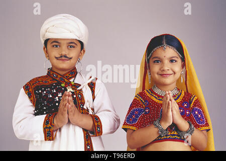 PORTRAIT D'UN COUPLE DE GUJARAT en costume traditionnel. Ce sont des enfants âgés de 12 ans, qui sont habillés comme des adultes. Les MAINS SONT REPLIÉES DANS LA CALLE DE SOUHAITS Banque D'Images