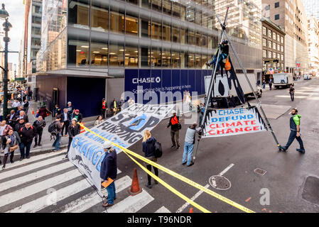 New York, États-Unis. 16 mai, 2019. Manifestations contre Chase Bank pour son rôle de la pire source de changement climatique a pris de l'ampleur, activistes du climat érigée et mise à l'échelle de deux étages, un trépied en acier, le blocage de la structure 47e st at Madison Ave, en face de son nouveau siège mondial de phare. L'un a été arrêté, tandis qu'un groupe de manifestants scandaient et soutien affiché des bannières appelant sur Chase à mettre fin à son financement massif de combustibles fossiles. Crédit : Erik McGregor/Pacific Press/Alamy Live News Banque D'Images