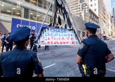 New York, États-Unis. 16 mai, 2019. Manifestations contre Chase Bank pour son rôle de la pire source de changement climatique a pris de l'ampleur, activistes du climat érigée et mise à l'échelle de deux étages, un trépied en acier, le blocage de la structure 47e st at Madison Ave, en face de son nouveau siège mondial de phare. L'un a été arrêté, tandis qu'un groupe de manifestants scandaient et soutien affiché des bannières appelant sur Chase à mettre fin à son financement massif de combustibles fossiles. Crédit : Erik McGregor/Pacific Press/Alamy Live News Banque D'Images