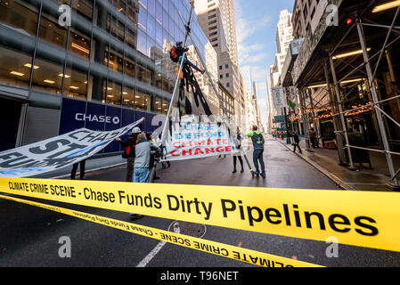 New York, États-Unis. 16 mai, 2019. Manifestations contre Chase Bank pour son rôle de la pire source de changement climatique a pris de l'ampleur, activistes du climat érigée et mise à l'échelle de deux étages, un trépied en acier, le blocage de la structure 47e st at Madison Ave, en face de son nouveau siège mondial de phare. L'un a été arrêté, tandis qu'un groupe de manifestants scandaient et soutien affiché des bannières appelant sur Chase à mettre fin à son financement massif de combustibles fossiles. Crédit : Erik McGregor/Pacific Press/Alamy Live News Banque D'Images