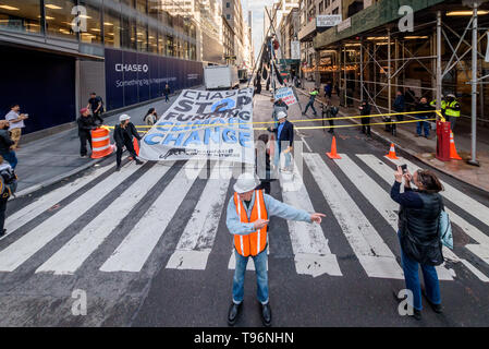 New York, États-Unis. 16 mai, 2019. Manifestations contre Chase Bank pour son rôle de la pire source de changement climatique a pris de l'ampleur, activistes du climat érigée et mise à l'échelle de deux étages, un trépied en acier, le blocage de la structure 47e st at Madison Ave, en face de son nouveau siège mondial de phare. L'un a été arrêté, tandis qu'un groupe de manifestants scandaient et soutien affiché des bannières appelant sur Chase à mettre fin à son financement massif de combustibles fossiles. Crédit : Erik McGregor/Pacific Press/Alamy Live News Banque D'Images