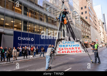 New York, États-Unis. 16 mai, 2019. Manifestations contre Chase Bank pour son rôle de la pire source de changement climatique a pris de l'ampleur, activistes du climat érigée et mise à l'échelle de deux étages, un trépied en acier, le blocage de la structure 47e st at Madison Ave, en face de son nouveau siège mondial de phare. L'un a été arrêté, tandis qu'un groupe de manifestants scandaient et soutien affiché des bannières appelant sur Chase à mettre fin à son financement massif de combustibles fossiles. Crédit : Erik McGregor/Pacific Press/Alamy Live News Banque D'Images