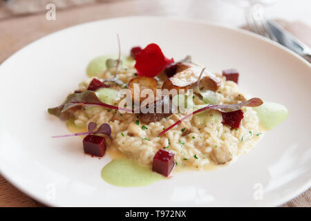 Risotto aux cèpes poêlés sur plaque porcelaine blanche Banque D'Images