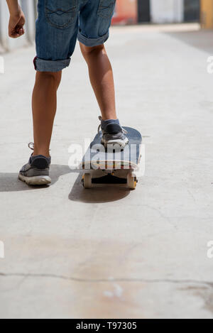 Vue arrière d'un jeune skateur professionnel jambes équitation sur planche Banque D'Images