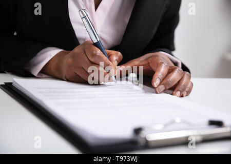 Close-up of Woman's Hand signature sur les papiers de plus de 24 Banque D'Images