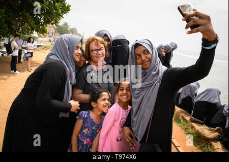 Un visiteur étranger ayant sa photo prise avec les étudiants locaux, Galle, Sri Lanka Banque D'Images