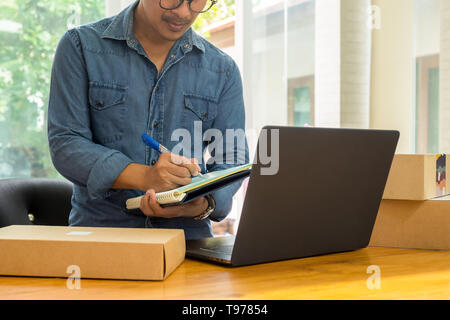 Les propriétaires de PME inventaire contrôle avec un ordinateur portable sur la table. Banque D'Images