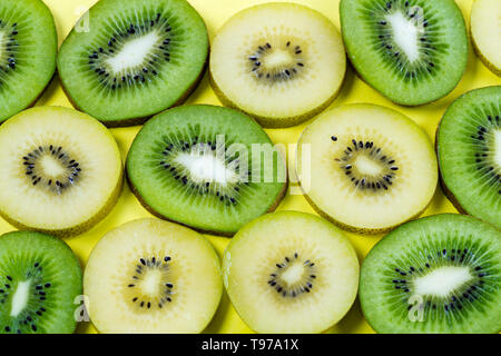 Vue horizontale de coupes d'un jaune doré et vert kiwi sur un fond jaune à contraste élevé Banque D'Images