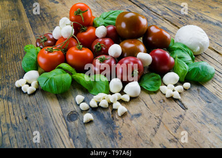 Aliments biologiques colorés savoureux ingrédients pour salade tomate mozzarella sur une table en bois rustique Banque D'Images