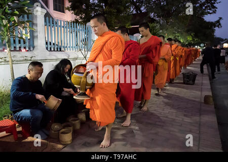 Luang Prabang - 15 janvier 2019 : Les gens faire l'aumône aux moines bouddhistes dans les rues de Luang Prabang, Laos Banque D'Images