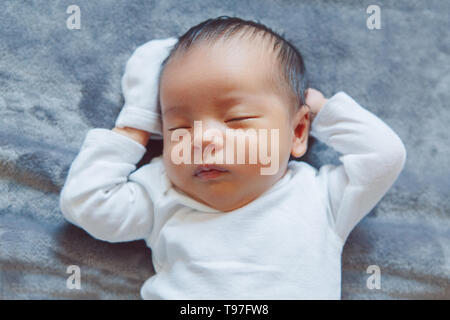 Closeup portrait of cute adorable Chinoise Asiatique couchage mixed race Naissance bebe Fille Garçon couché sur lit dans la chambre. Enfance heureuse en bonne santé plongée ethnique Banque D'Images