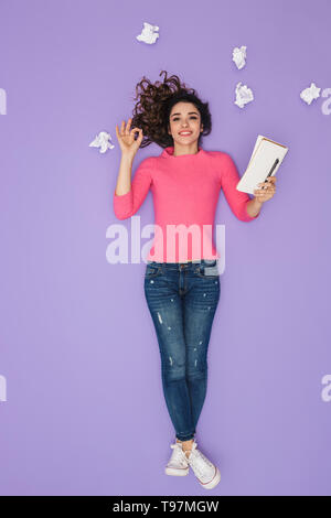 Longueur totale de l'image 20s caucasian woman in casual clothing holding notes de papier tout en se posant sur une idée ou un bulle de pensée au-dessus de sa tête plus isolés Banque D'Images