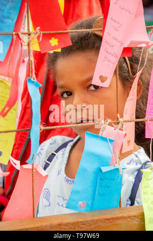 Un Africain américain 7-year-old girl lit un "Mur des souhaits" des rubans pour le Nouvel An lunaire au cours d'une célébration du Têt vietnamien à Costa Mesa, CA. Banque D'Images