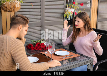 Jeune couple ayant des arguments sur ce jour en cafe Banque D'Images