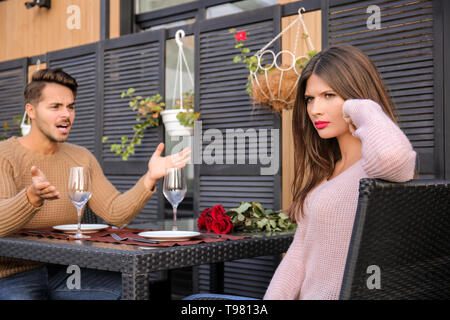 Jeune couple ayant des arguments sur ce jour en cafe Banque D'Images