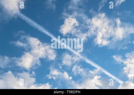 Sentier chimique de carburant des compagnies aériennes dans le ciel bleu avec des nuages blancs. Idéal pour les concepts et les milieux. Banque D'Images