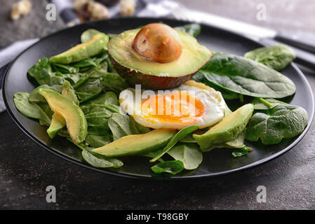 Œuf frit délicieux avec de l'avocat et les épinards sur la plaque Banque D'Images