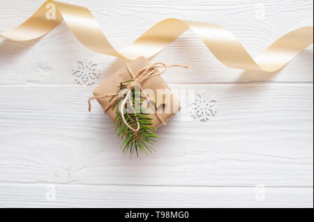 Maquette de Noël boîte cadeau kraft avec fond en bois blanc sur ruban beige Banque D'Images