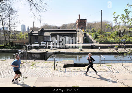 Les gens le jogging par blocage de St Pancras avec verrouillage Keepers Cottage et Waterpoint en arrière-plan, Regent's Canal, King's Cross, Londres, Angleterre, Royaume-Uni Banque D'Images