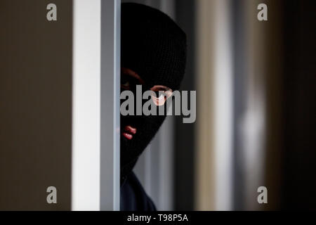 Voleur masqué avec balaclava en attente dans la chambre au cambriolage Banque D'Images