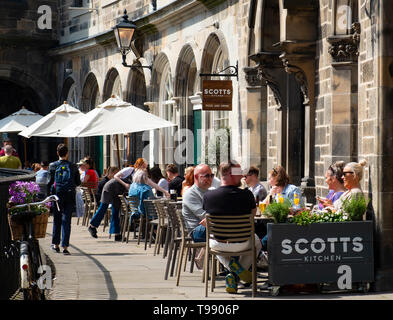 Les gens de boire et manger dans les restaurants de beau temps sur la terrasse au-dessus de Victoria Victoria Street dans la vieille ville d'Édimbourg, Écosse, Royaume-Uni Banque D'Images