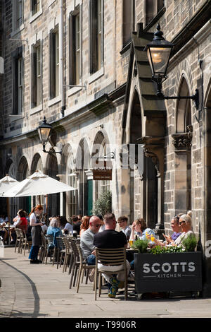 Les gens de boire et manger dans les restaurants de beau temps sur la terrasse au-dessus de Victoria Victoria Street dans la vieille ville d'Édimbourg, Écosse, Royaume-Uni Banque D'Images