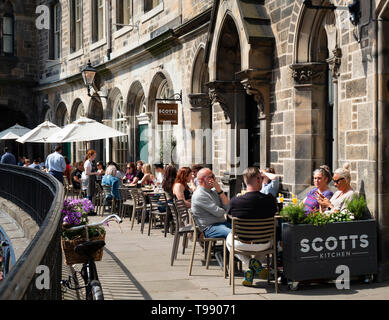 Les gens de boire et manger dans les restaurants de beau temps sur la terrasse au-dessus de Victoria Victoria Street dans la vieille ville d'Édimbourg, Écosse, Royaume-Uni Banque D'Images