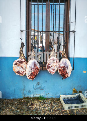 Les jambes de l'espagnol jamon iberico pendaison. Fête traditionnelle dans l'abattage de porcs ibériques Cortelazor, Huelva, Espagne. Banque D'Images