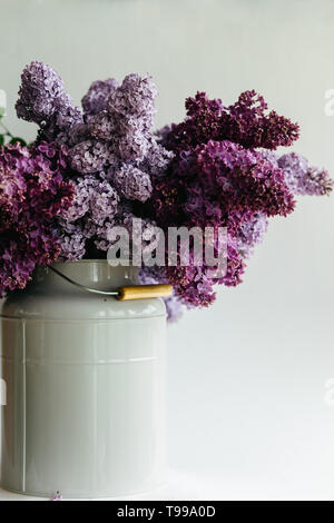 Bouquet de lilas mauve dans un élégant vase de fleurs sur table en bois Banque D'Images