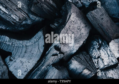 Charbons noir close up l'arrière-plan. La texture du bois brûlé. Poutres apparentes dans les grillades, les cendres de barbecue en vue d'en haut. Charbon couvant naturelles heap abstrait toile. Bois gris composition minimaliste Banque D'Images