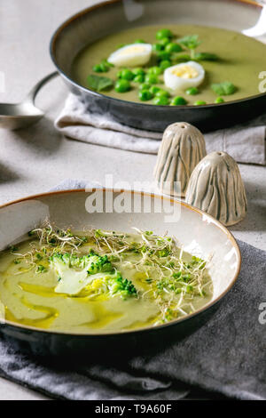 Variété de légumes vert asperges, brocoli, pois et décoré par les verts, légumes, œufs de caille, crème, huile d'olive, de bols de céramique plus de Gray Banque D'Images