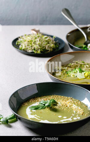 Variété de légumes vert asperges, brocoli, pois et décoré par les verts, légumes, œufs de caille, crème, huile d'olive, de bols de céramique plus de Gray Banque D'Images