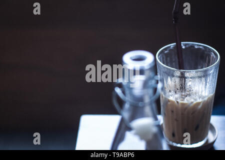 Latte Café glacé avec de la glace sur la table en bois clair de l'eau vintage premier-plan flou avec l'espace pour le texte. Banque D'Images