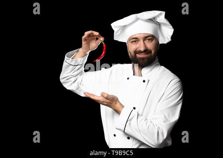 Male chef avec piment rouge sur fond sombre Banque D'Images