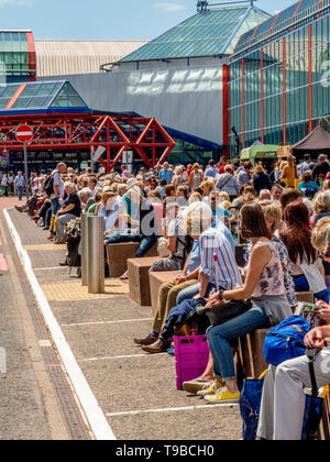 La foule assistant à un spectacle à l'extérieur, au soleil à NEC, Birmingham, UK. Banque D'Images